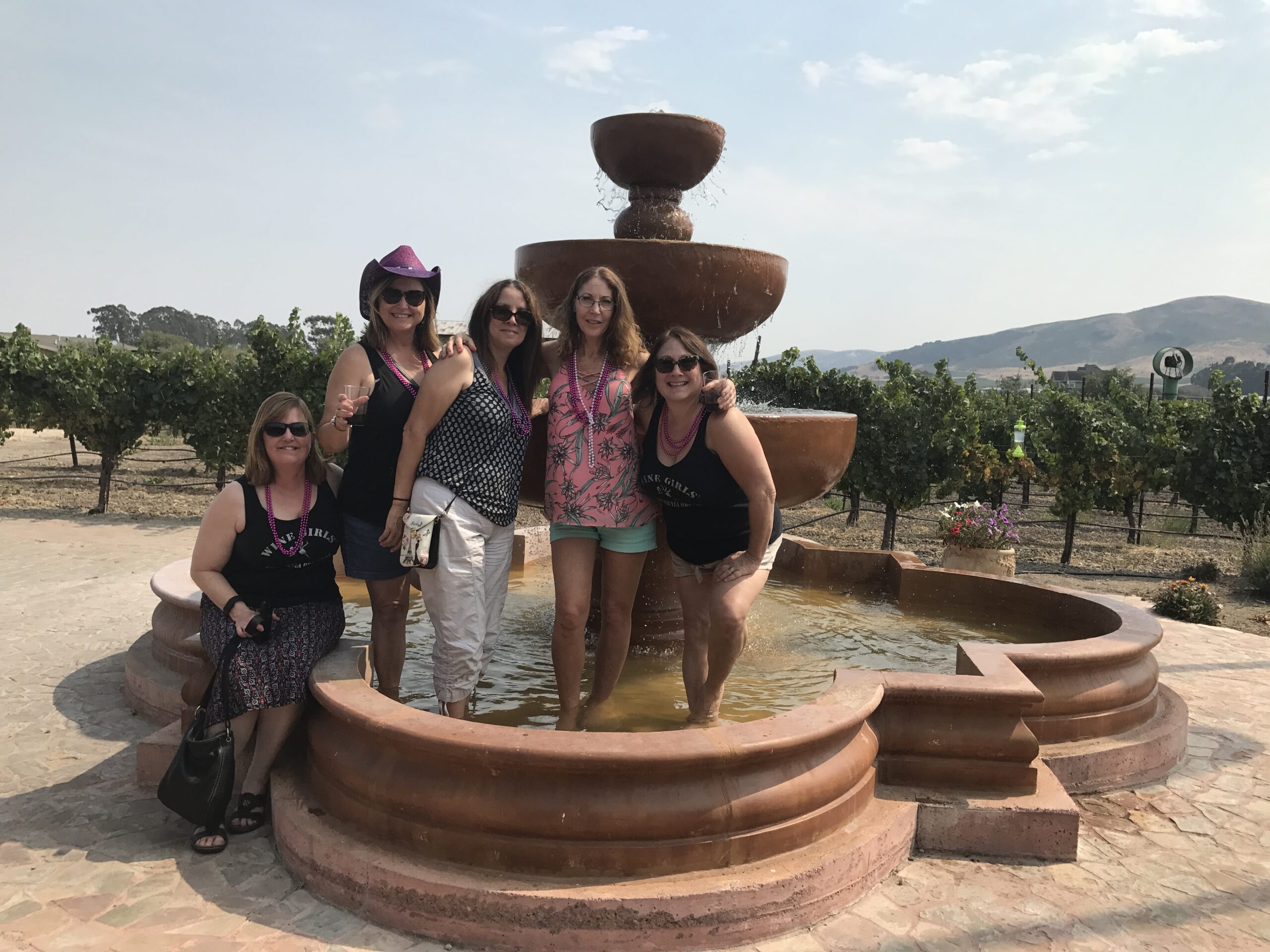 Some winegirls in a winery fountain